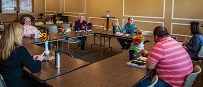 Six members of the Personnel committee sitting at 4 tables arranged in a square shape