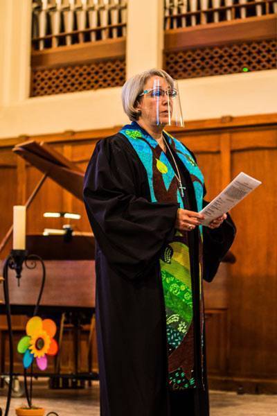 pastor Katie standing in her robe at the pulpit