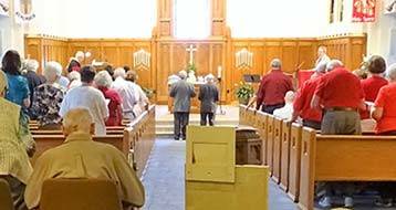 people standing and worshipping in the sanctuary